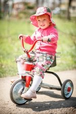 21233331-little-girl-driving-her-tricycle-smiling.jpg